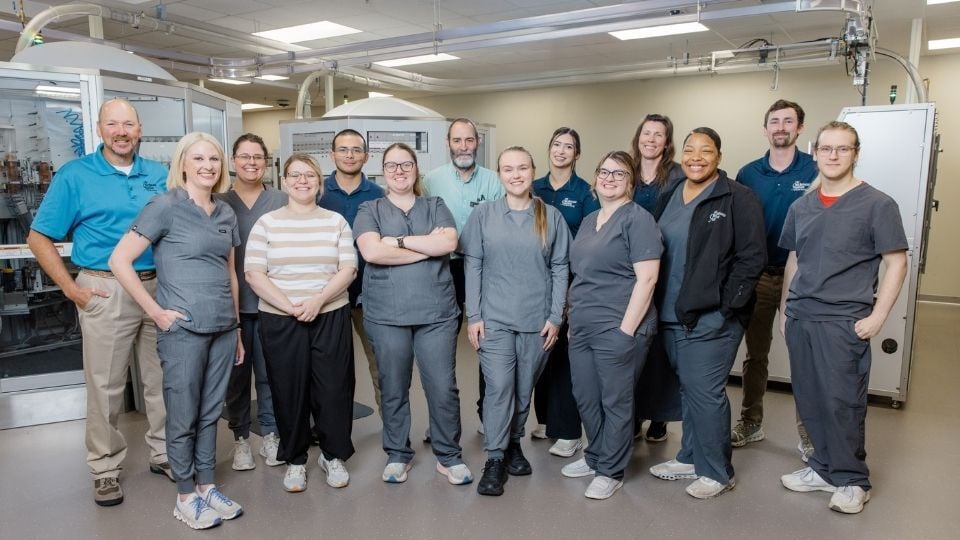 Pharmacy team members from the Chickasaw Nation Department of Health standing together inside a pharmacy workspace, representing collaboration and mentorship within the PGY1 Pharmacy Residency Program